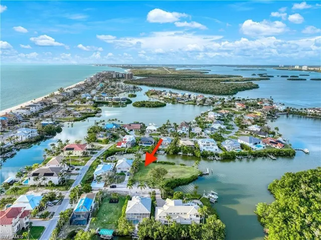 Aerial view of property and surrounding area featuring nearby suburban area and a nearby body of water