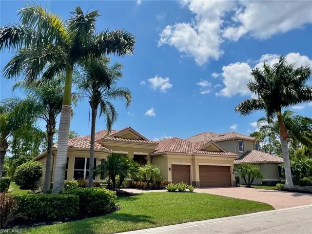 Mediterranean / spanish home with a garage, a tile roof, stucco siding, and a front yard