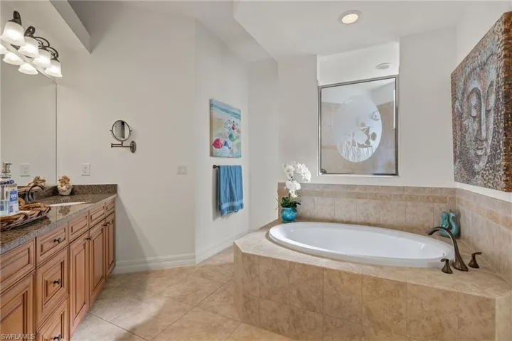 Full bathroom featuring tile patterned flooring, vanity, and a bath