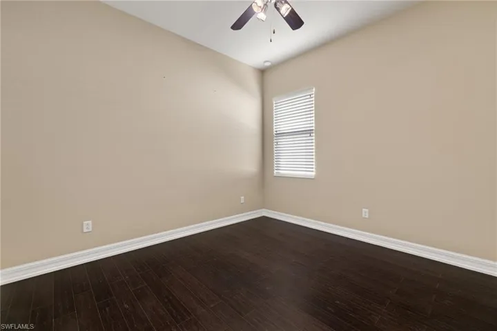 Spare room with ceiling fan and dark wood finished floors