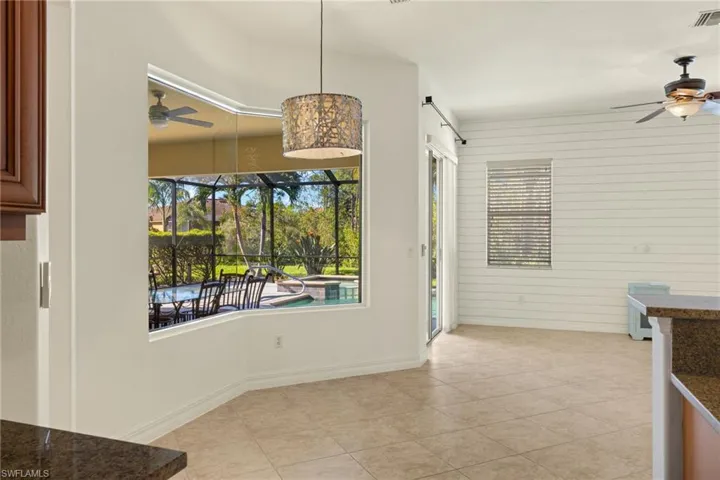 Unfurnished dining area with a ceiling fan, light tile patterned floors, and wood walls