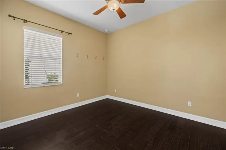 Spare room with ceiling fan and dark wood-style flooring