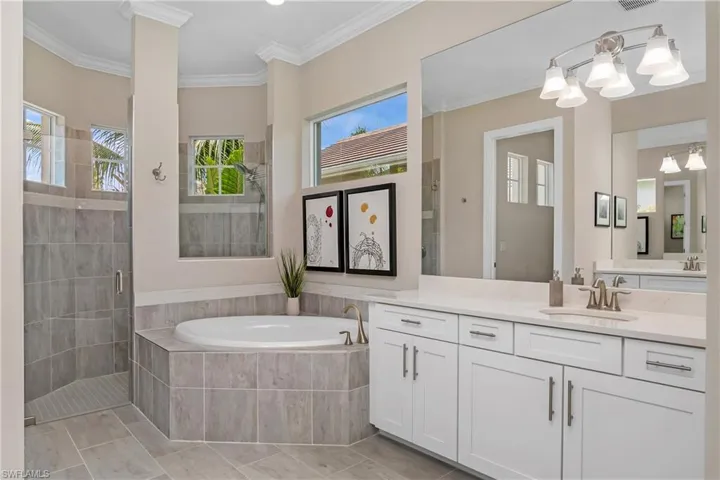 You'll love this spa-like bathroom featuring plenty of natural light, dual sinks, a soaking tub, and a large walk-in shower.