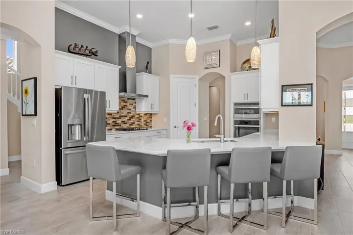 Plenty of cabinet space, walk-in pantry, custom backsplash, and designer lighting make this kitchen unique and perfect for entertaining guests.
