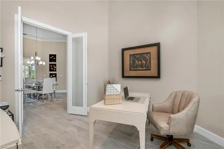 Spacious den/office features high ceilings and glass panel french doors.