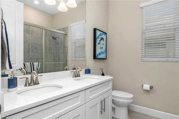 Additional Guest Bath with dual sinks and walk-in shower and glass enclosure.