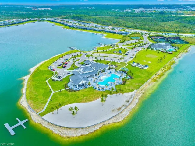 Aerial view shows social club with lakeside beach and bocce courts/horseshoes in the distance.