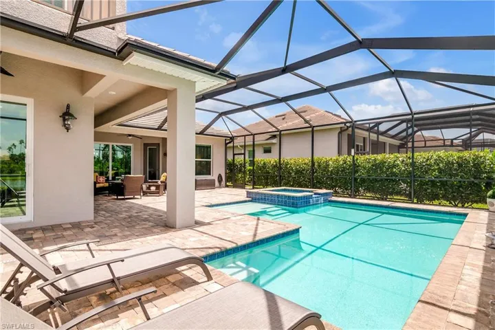 View of pool featuring a patio, an in ground hot tub, and a lanai