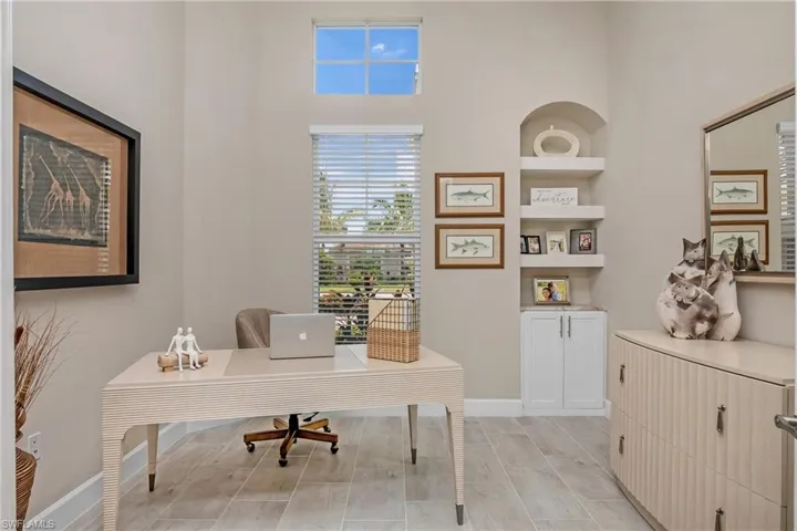 Den sits at the front of the home, with custom built in cabinet, shelved niche, and lots of natural light with additional transom window.