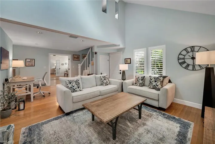 Living room with hardwood / wood-style floors and a towering ceiling