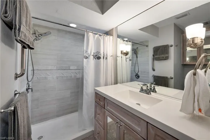 Bathroom with a shower with curtain and vanity