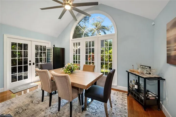 Dining room with ceiling fan, lofted ceiling, dark wood-type flooring, and french doors