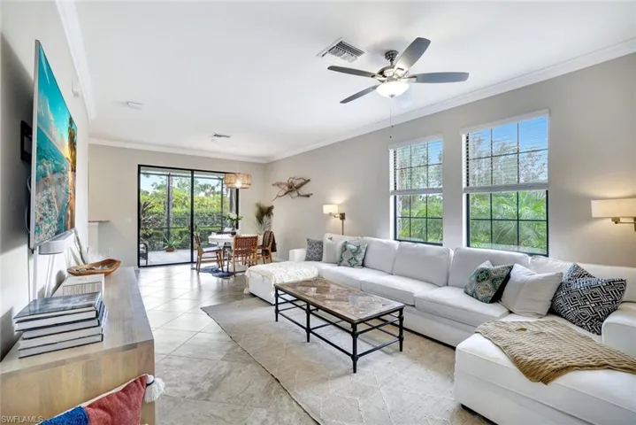 Light and bright Living room featuring ceiling fan, crown molding, and tile floors.