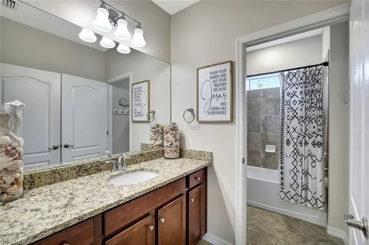 Guest Bathroom with granite counter and a private shower/ bath combo with water closet.