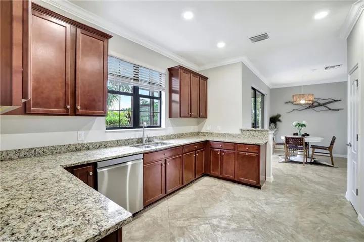 Kitchen with crown molding, granite countertops, stainless steel appliances and a pantry.