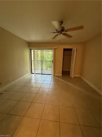 Empty room featuring light tile patterned flooring and a ceiling fan