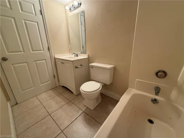 Bathroom with a tub, tile patterned flooring, and vanity