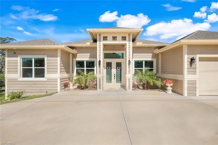 View of front of property featuring a shingled roof, driveway, and an attached garage
