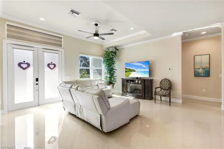 Living area with ornamental molding, french doors, a ceiling fan, recessed lighting, and a fireplace
