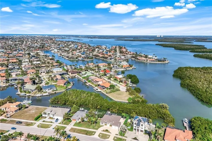Aerial view of property and surrounding area featuring nearby suburban area