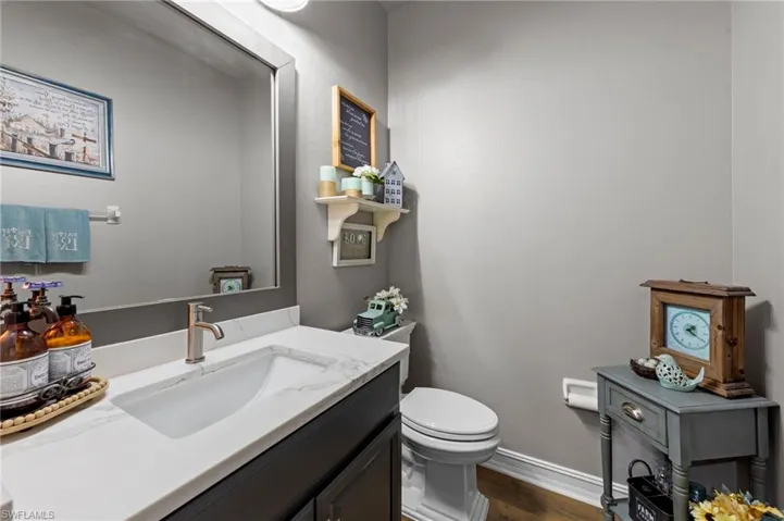 Half bathroom featuring vanity and dark wood-style floors