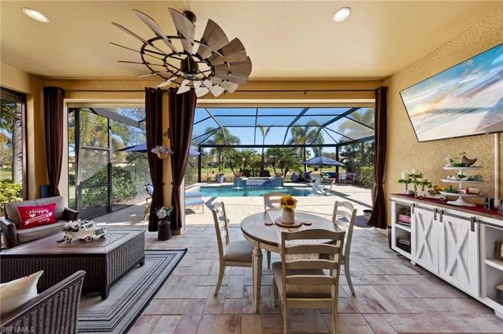 View of patio / terrace featuring a sunroom, an outdoor pool, a lanai, ceiling fan, and outdoor dining space