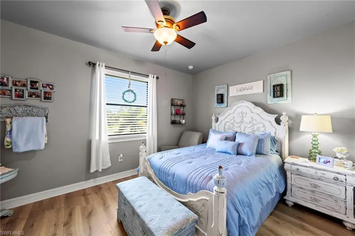 Guest Bedroom with wood finished floors and ceiling fan