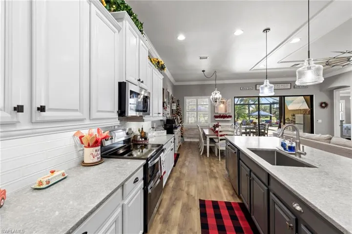 Kitchen featuring white cabinets, appliances with stainless steel finishes, open floor plan, pendant lighting, and recessed lighting