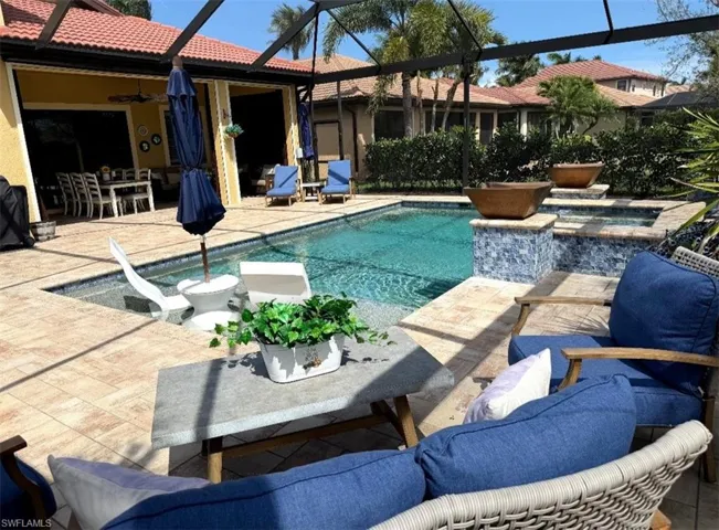 Combined pool / hot tub with a patio, a lanai, outdoor dining area, and a sunroom