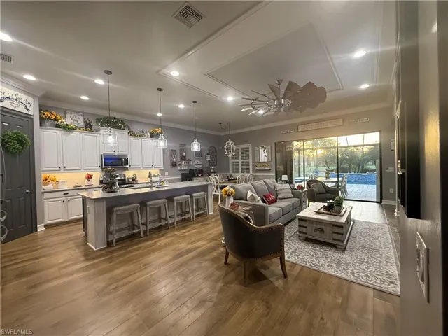 Living room featuring ceiling fan, recessed lighting, ornamental molding, and dark wood-style flooring