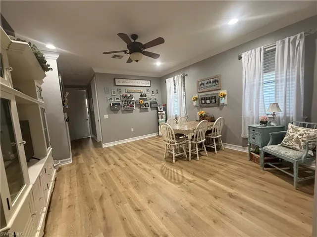 Dining space with light wood-style floors, a ceiling fan, crown molding, and recessed lighting