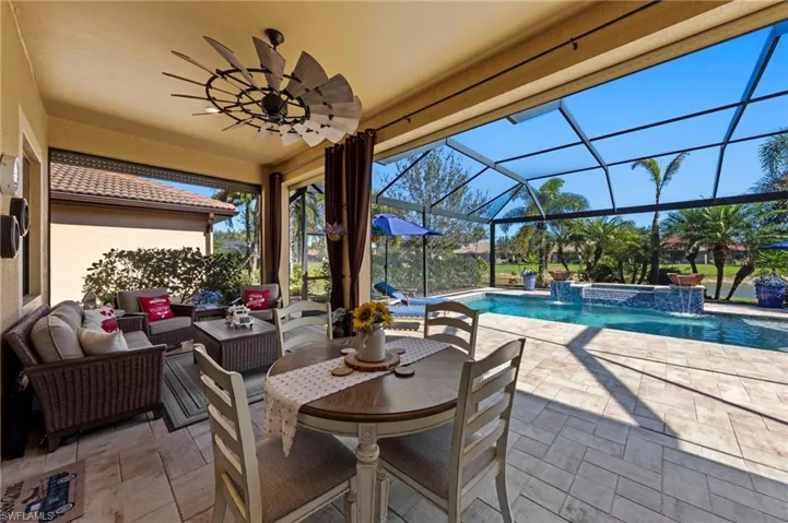 View of patio / terrace with a sunroom, a lanai, a ceiling fan, an outdoor pool, and a jacuzzi