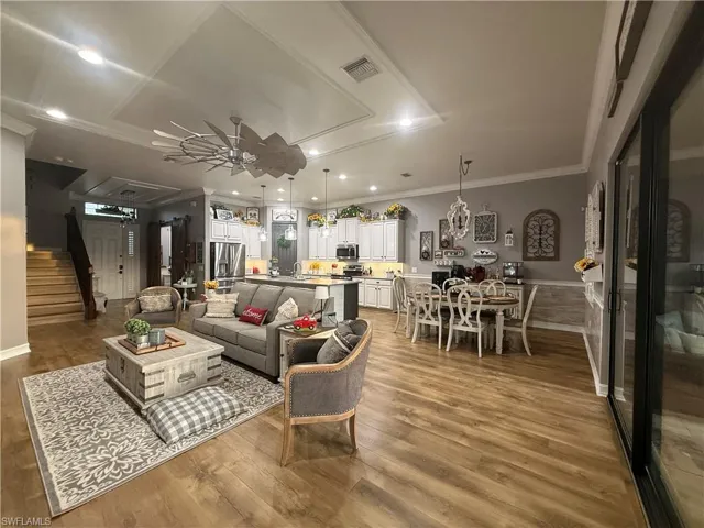 Living area featuring ceiling fan, ornamental molding, light wood-style floors, and recessed lighting