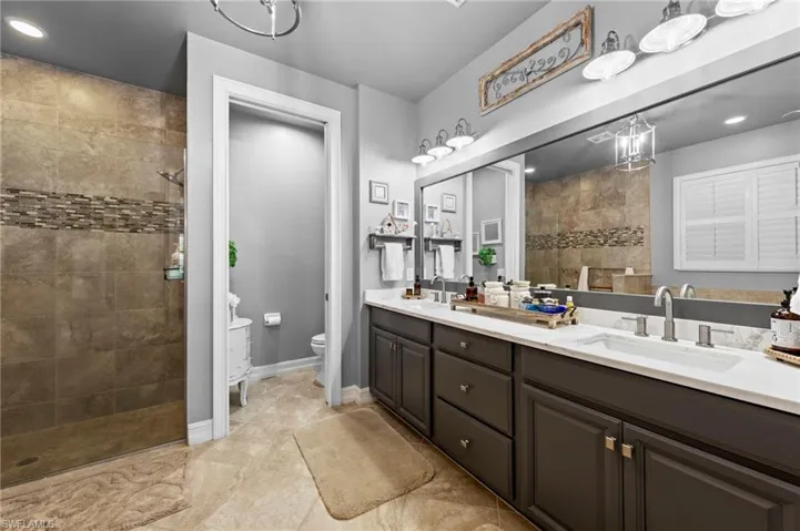 Full bath with a walk in shower, recessed lighting, and double vanity