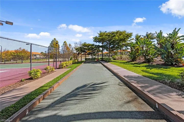 View of home's community with a tennis court