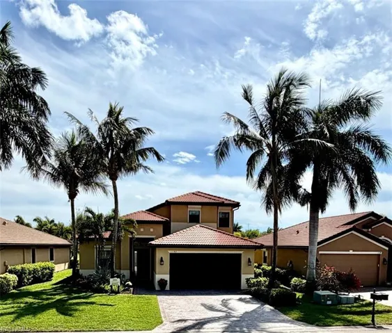 Mediterranean / spanish home featuring a front yard, stucco siding, an attached garage, driveway, and a tile roof