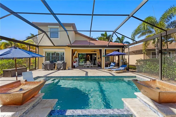 Swimming pool with a hot tub, a sunroom, a patio, and glass enclosure