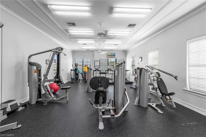 Exercise room featuring a ceiling fan and ornamental molding
