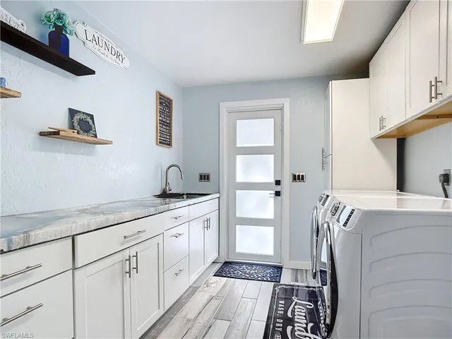 Laundry room with designer concrete countertop, lots of cabinet space, for washing machine and clothes dryer