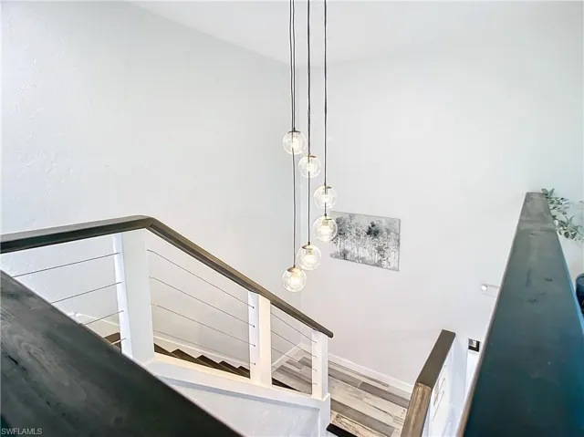 Stairs to 2nd level with wood bannister and wood finished steps