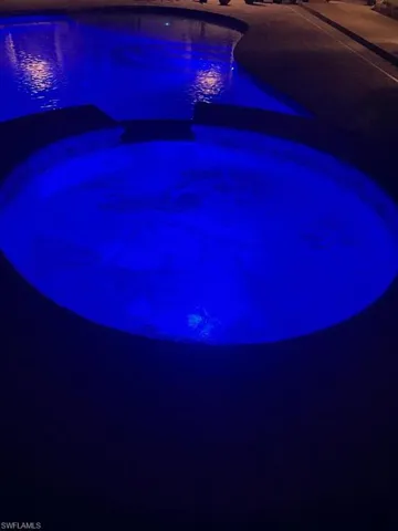 Nighttime View of pool featuring pool automation