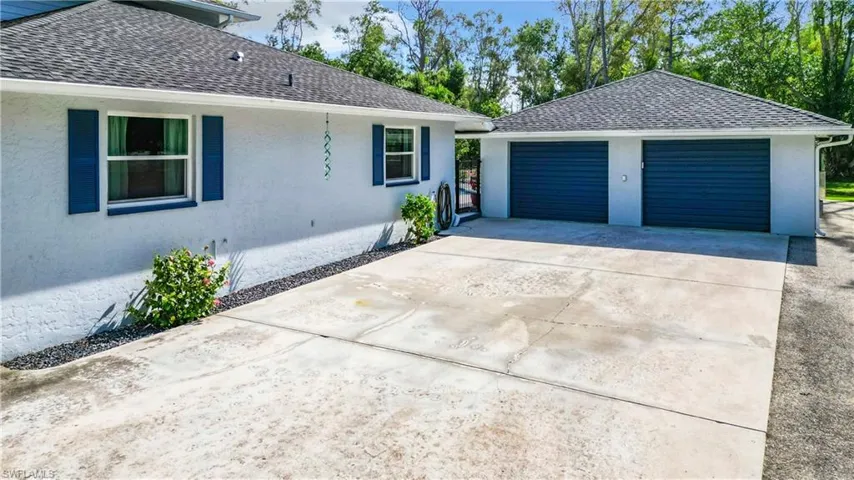 View of side of homegarages and large concrete driveway for ample parking