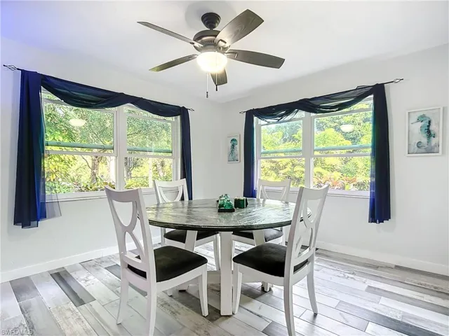 Diningroom featuring large windows for light airy dining and a designer ceiling fan