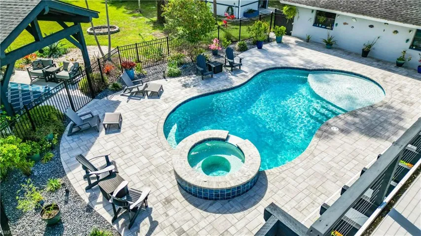 View of pool featuring a patio area, a pool with connected hot tub, and a fenced backyard