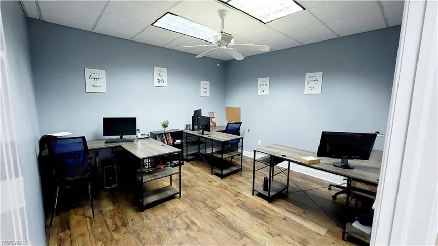 Office space with a drop ceiling, light hardwood / wood-style flooring, and ceiling fan
