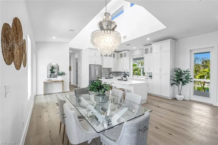Dining room featuring a chandelier, light wood-type flooring, baseboards, and recessed lighting