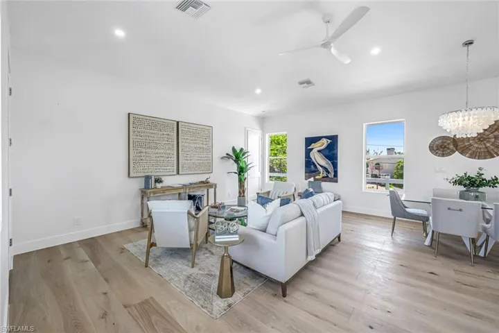 Living area featuring a chandelier, light wood-type flooring, baseboards, recessed lighting, and ceiling fan