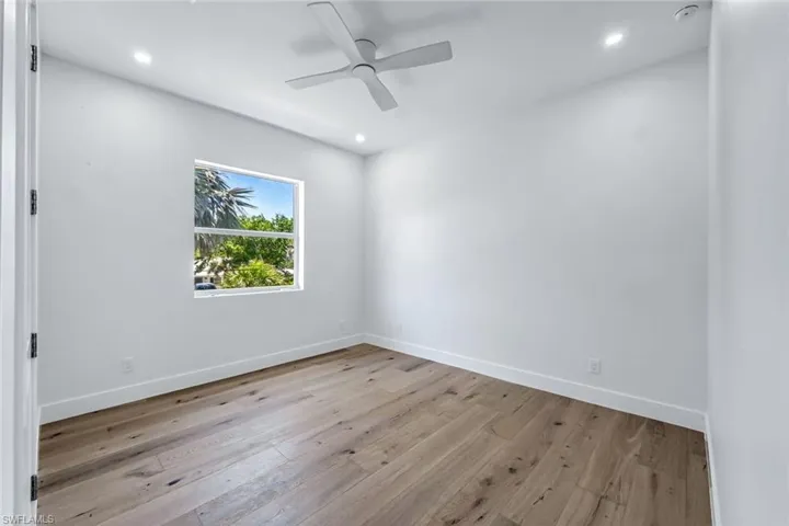 Empty room featuring hardwood / wood-style floors, recessed lighting, baseboards, and ceiling fan