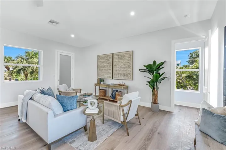 Living room featuring baseboards, light wood-style flooring, and recessed lighting