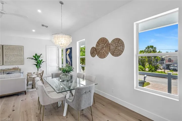 Dining space featuring baseboards, light wood finished floors, a chandelier, recessed lighting, and a ceiling fan